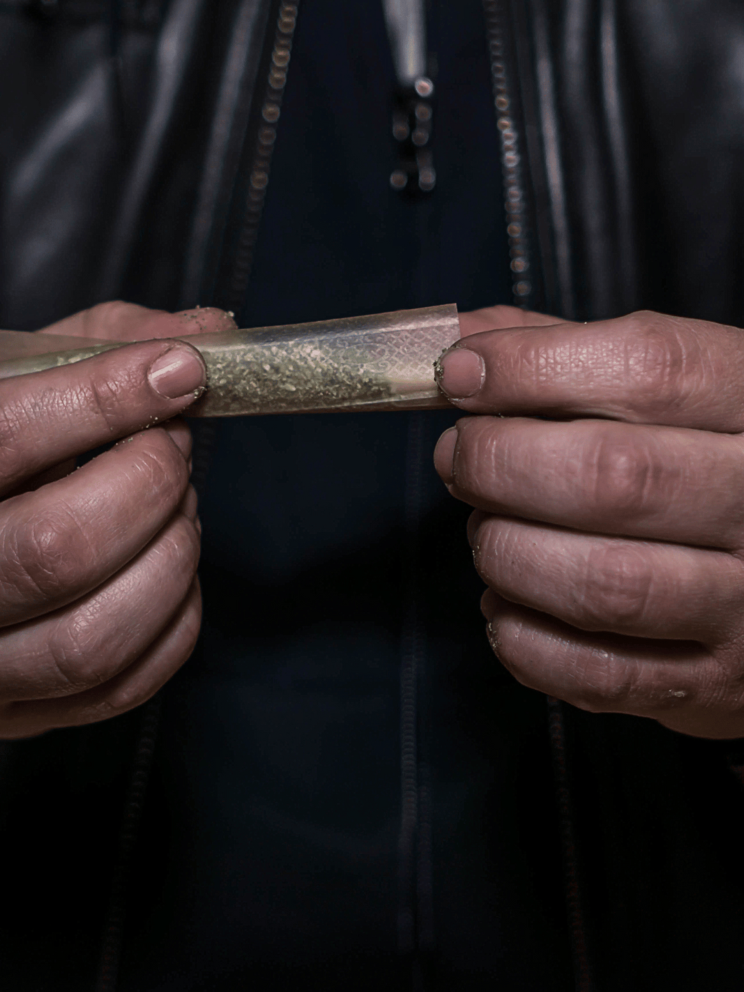 zwei Hände die einen Joint drehen
